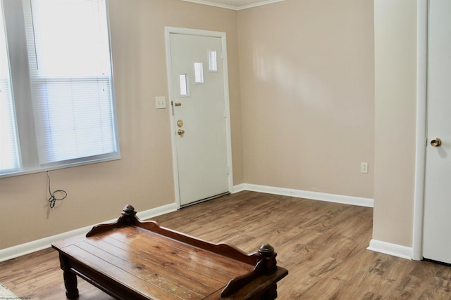 entryway featuring light wood-type flooring and crown molding