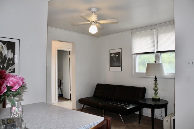 living room with ornamental molding, light colored carpet, and ceiling fan