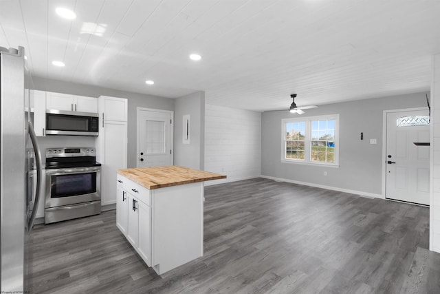 kitchen featuring appliances with stainless steel finishes, white cabinets, dark hardwood / wood-style floors, butcher block counters, and ceiling fan