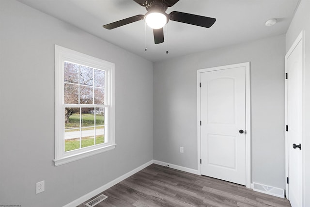 empty room with ceiling fan and dark hardwood / wood-style flooring