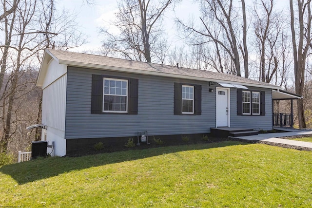 view of front of home featuring central AC unit and a front lawn