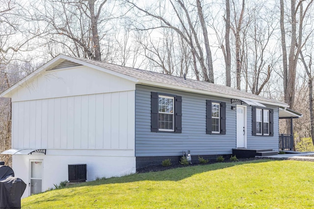 view of front of house featuring central air condition unit and a front lawn