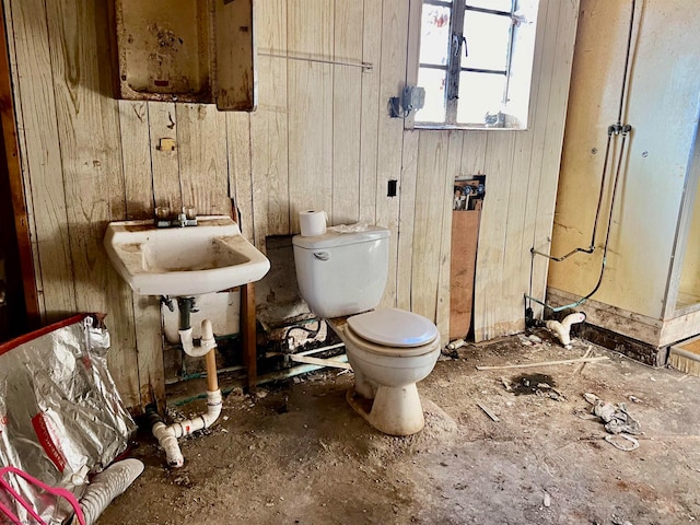 bathroom with wood walls and toilet