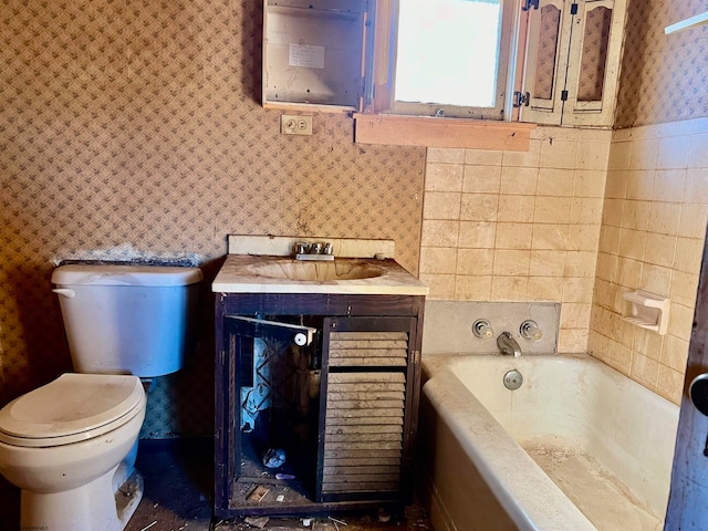 bathroom with vanity, a washtub, and toilet