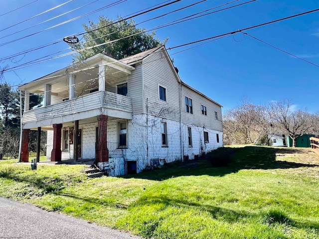 view of front of house with a balcony and a front lawn