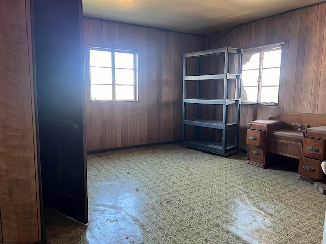 office area with tile flooring and wood walls