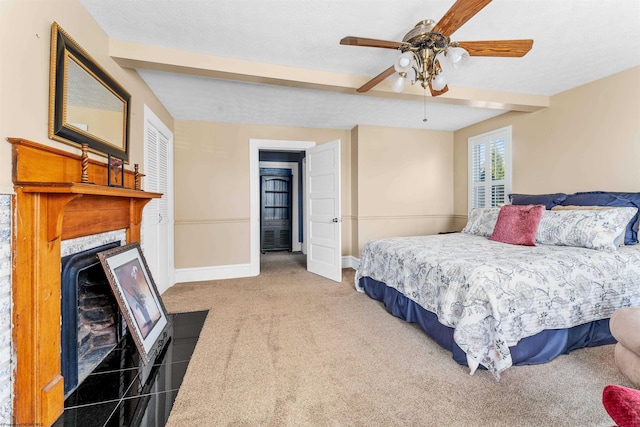 carpeted bedroom featuring ceiling fan, a textured ceiling, and a fireplace