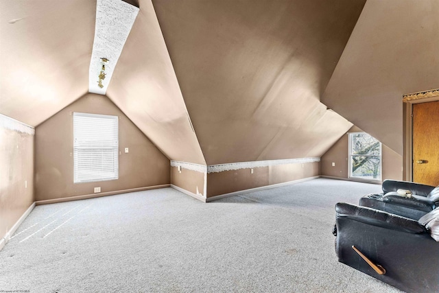 bonus room with light carpet and vaulted ceiling