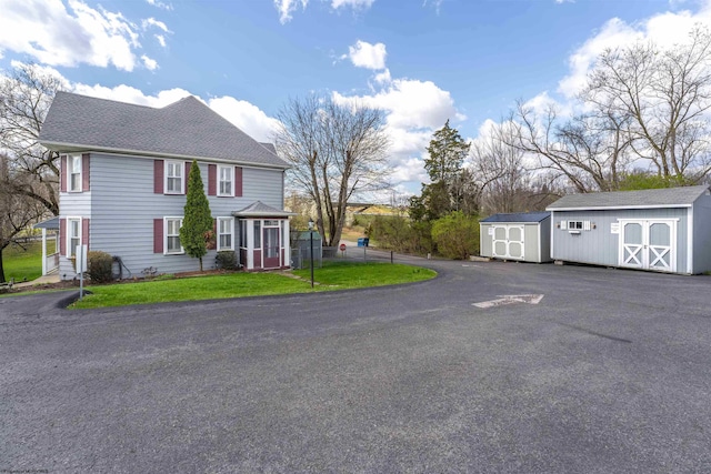 view of front of property with a front yard and a shed