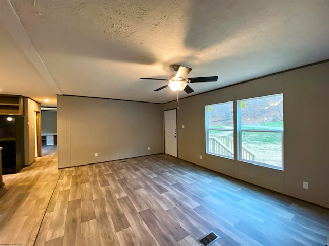 unfurnished living room featuring a textured ceiling, ceiling fan, and hardwood / wood-style flooring