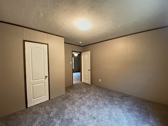 unfurnished bedroom featuring crown molding, a textured ceiling, and carpet floors