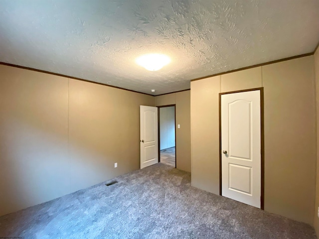 unfurnished bedroom with carpet flooring, crown molding, and a textured ceiling