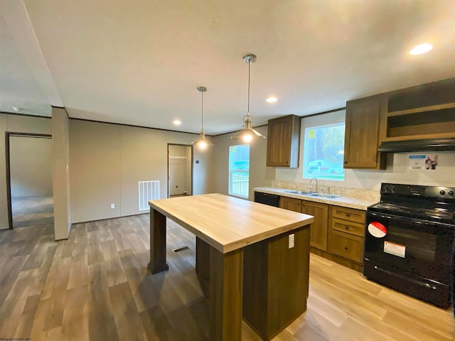 kitchen featuring light hardwood / wood-style flooring, black electric range, wood counters, a kitchen island, and hanging light fixtures