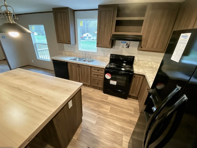 kitchen featuring light hardwood / wood-style flooring, black appliances, sink, and a healthy amount of sunlight