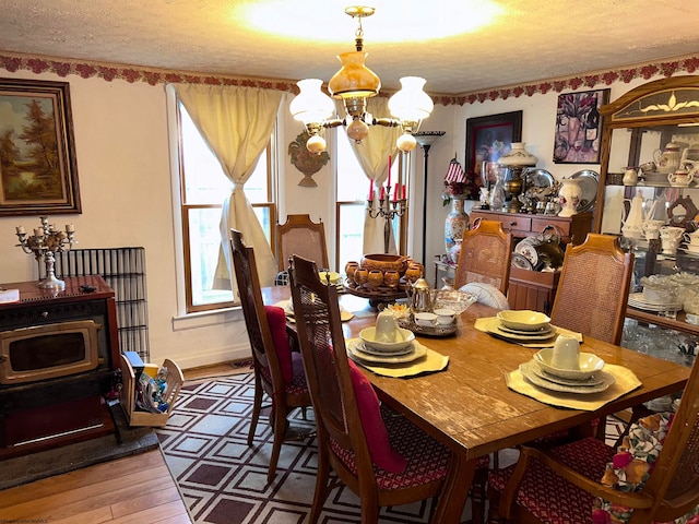 dining area featuring hardwood / wood-style floors, a textured ceiling, and a chandelier