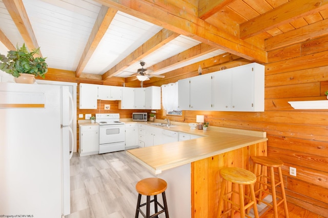 kitchen with white cabinetry, ceiling fan, beamed ceiling, white appliances, and a kitchen breakfast bar