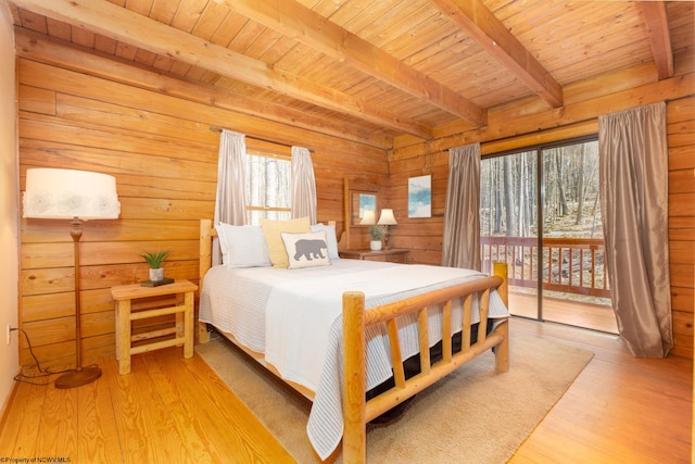 bedroom with light wood-type flooring, beamed ceiling, wooden ceiling, and multiple windows