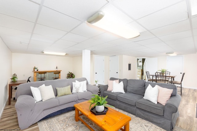 living room with a drop ceiling and light hardwood / wood-style floors