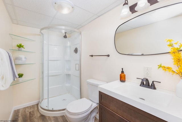 bathroom with toilet, an enclosed shower, a drop ceiling, oversized vanity, and hardwood / wood-style flooring