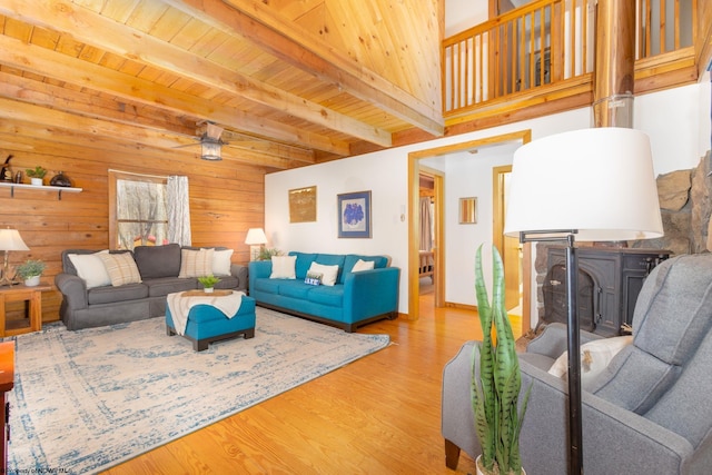 living room featuring wood ceiling, light hardwood / wood-style floors, ceiling fan, and beamed ceiling