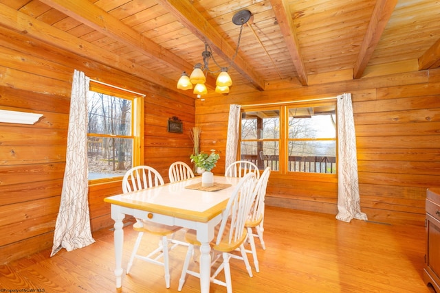 dining area featuring wooden ceiling, an inviting chandelier, beamed ceiling, and light hardwood / wood-style floors