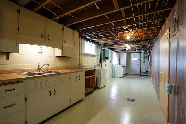 kitchen with cream cabinets, washer and dryer, and sink