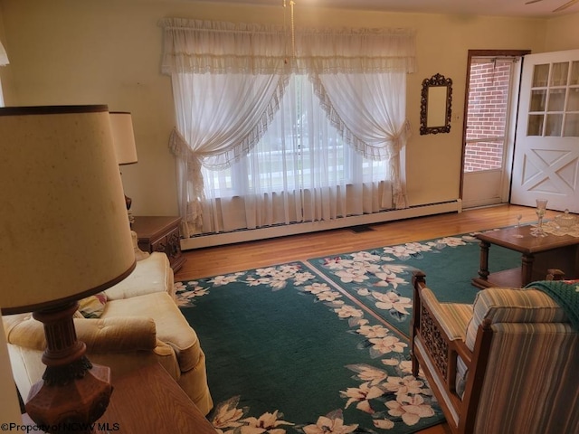 living room with light wood-type flooring and a baseboard radiator