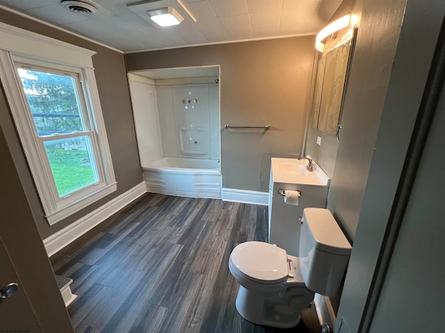 full bathroom featuring hardwood / wood-style floors, toilet, ornamental molding, vanity, and bathing tub / shower combination