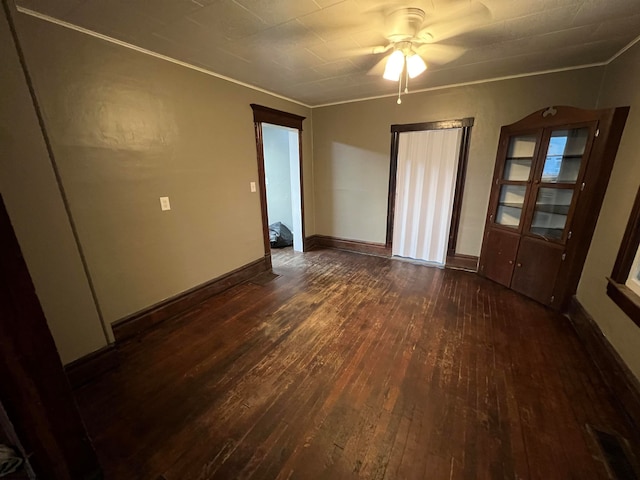 unfurnished room with dark hardwood / wood-style floors, ceiling fan, and crown molding