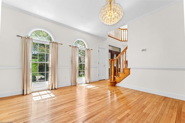 interior space featuring a notable chandelier, light hardwood / wood-style flooring, and crown molding