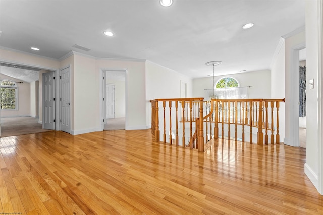 unfurnished room with light hardwood / wood-style floors and crown molding