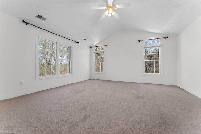 unfurnished room featuring light carpet, lofted ceiling, and a healthy amount of sunlight