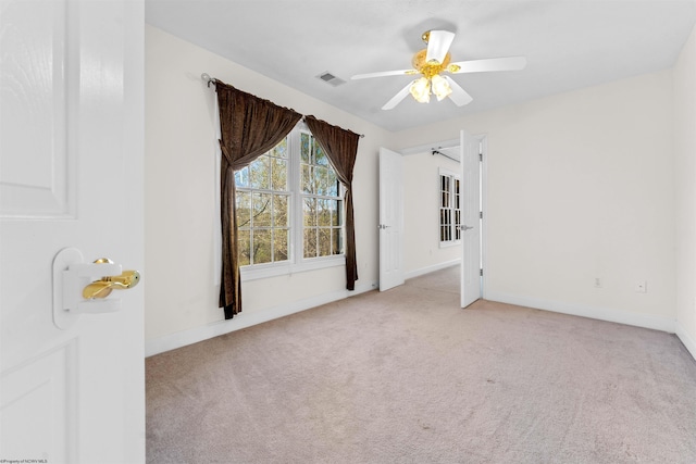 empty room featuring light colored carpet and ceiling fan