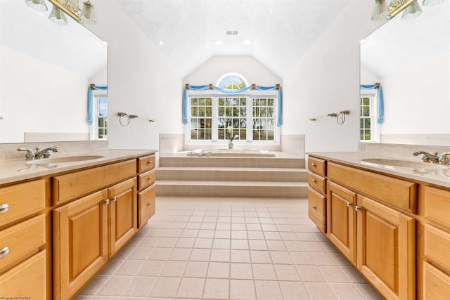 bathroom featuring large vanity, dual sinks, tiled tub, tile floors, and vaulted ceiling