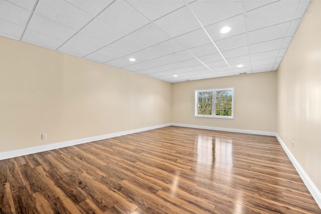 spare room featuring a drop ceiling and dark hardwood / wood-style floors