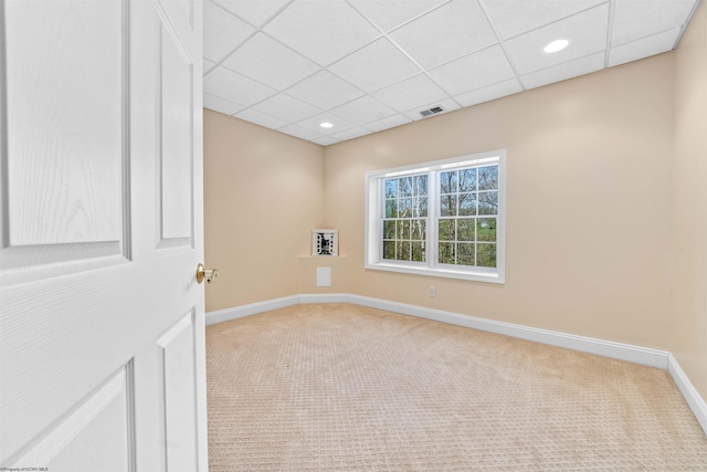 unfurnished room with a drop ceiling and light carpet