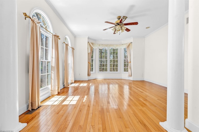 unfurnished room with ornate columns, ceiling fan, light hardwood / wood-style floors, and ornamental molding