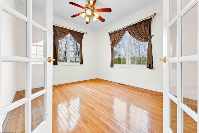 unfurnished room featuring ceiling fan, light hardwood / wood-style floors, and ornamental molding