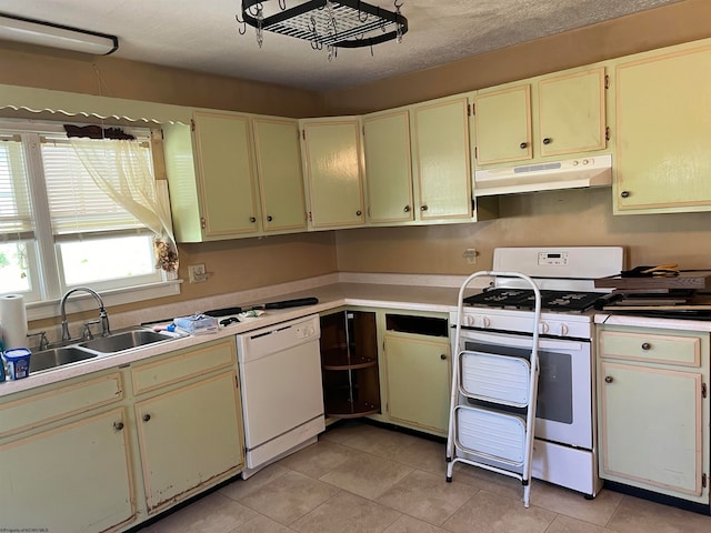 kitchen featuring white appliances, sink, and light tile floors