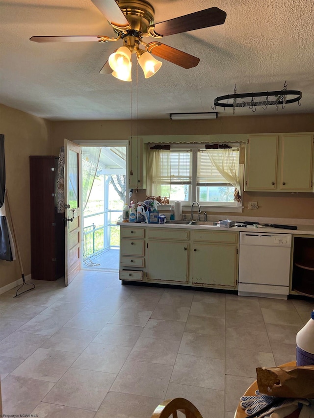 kitchen featuring white dishwasher, sink, light tile floors, ceiling fan, and a textured ceiling