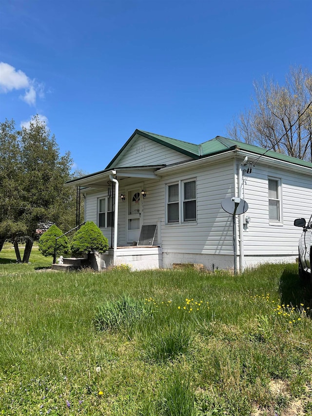 exterior space with covered porch and a front yard