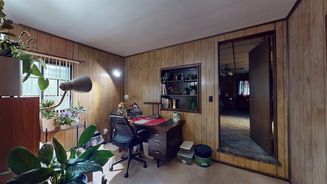 carpeted home office with wood walls