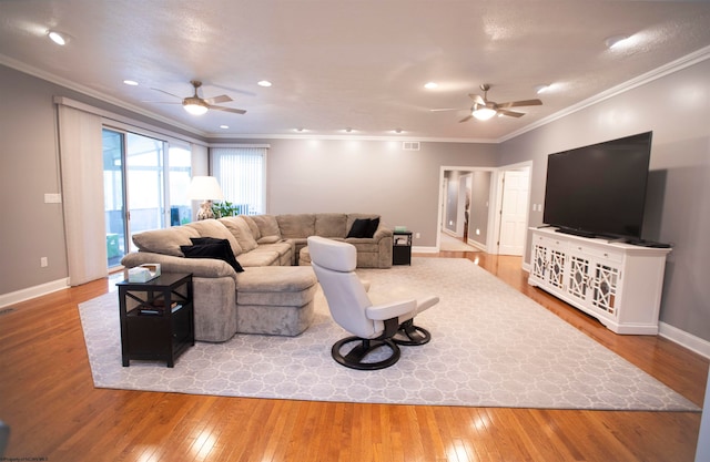 living room with ornamental molding, ceiling fan, and light wood-type flooring