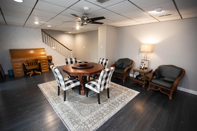 dining area featuring dark hardwood / wood-style floors, ceiling fan, and a drop ceiling