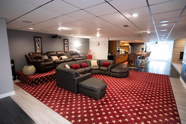 home theater room with hardwood / wood-style floors and a paneled ceiling