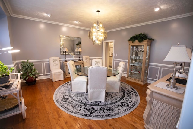 dining area with a chandelier, crown molding, dark hardwood / wood-style flooring, and a textured ceiling