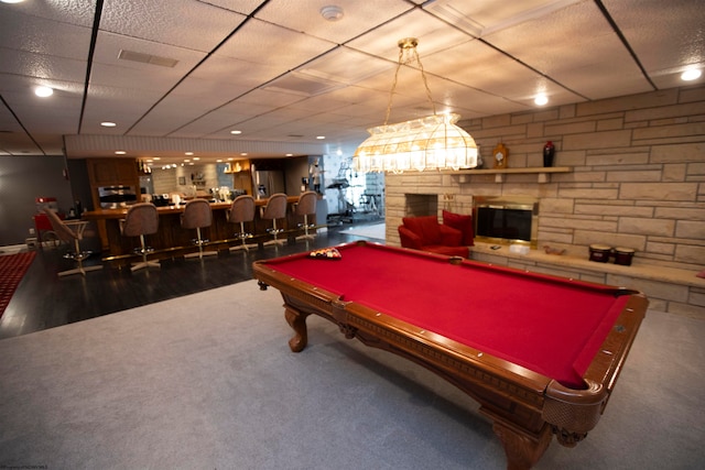 recreation room with bar area, dark carpet, a stone fireplace, and billiards