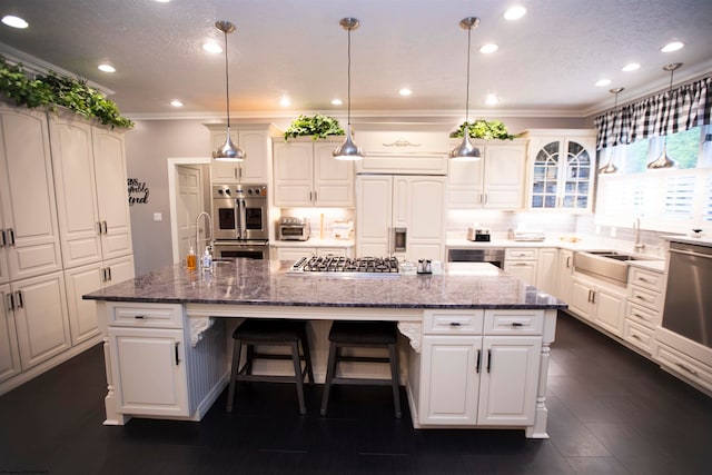 kitchen featuring sink, appliances with stainless steel finishes, an island with sink, and backsplash