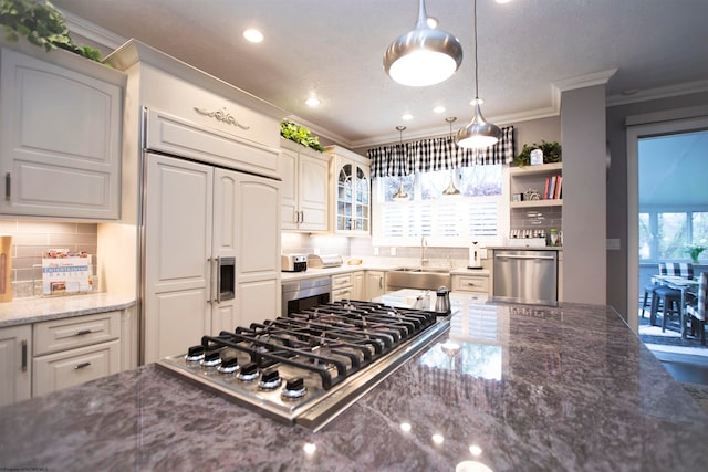 kitchen with appliances with stainless steel finishes, sink, tasteful backsplash, hanging light fixtures, and crown molding