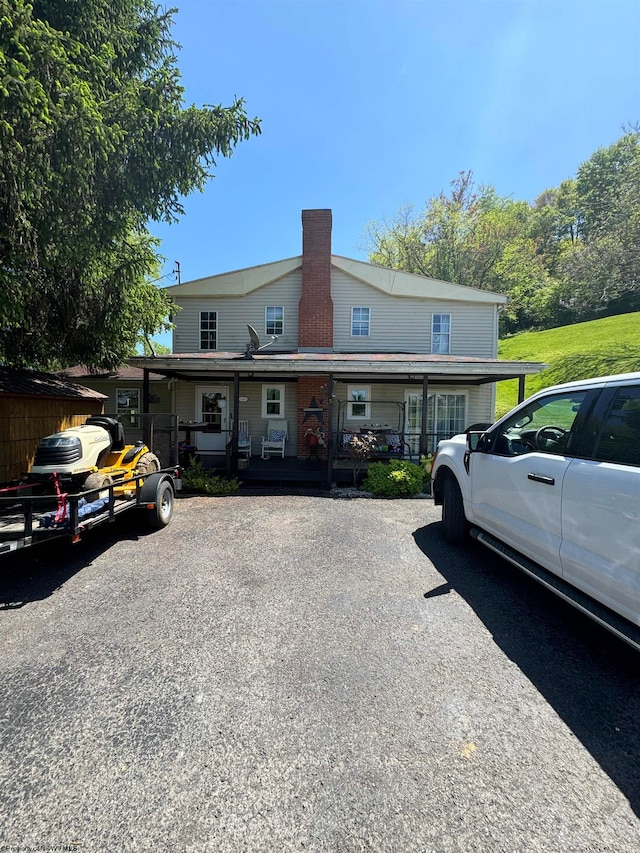 view of front of house featuring covered porch and a chimney